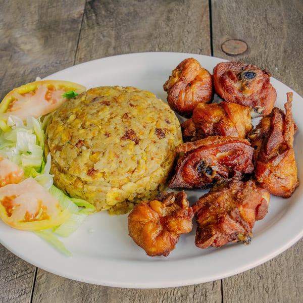 El Cerro's mofongo with fried chicken pieces and a side salad on a white plate.